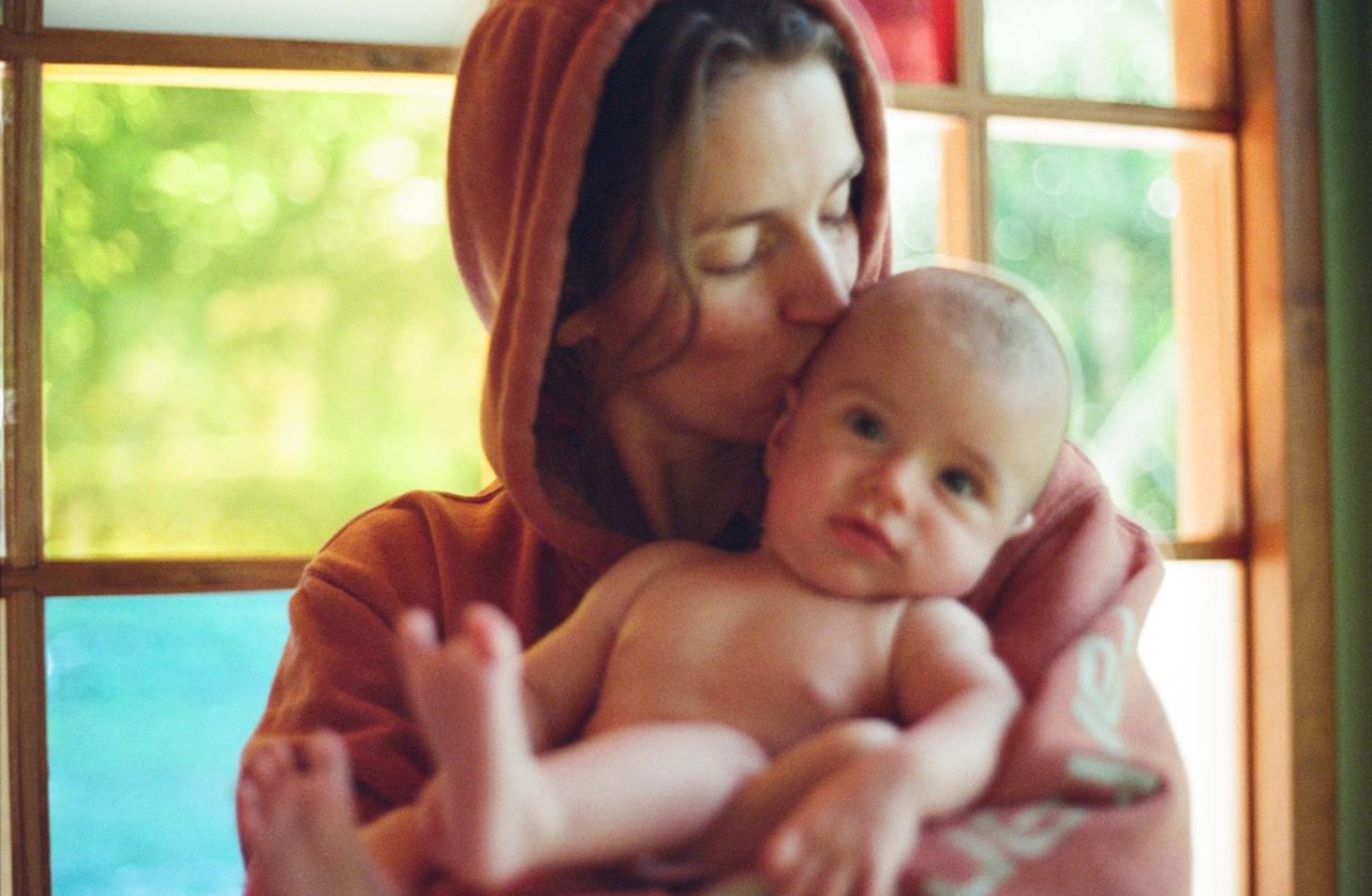 Ellie holding her child in warm afternoon light