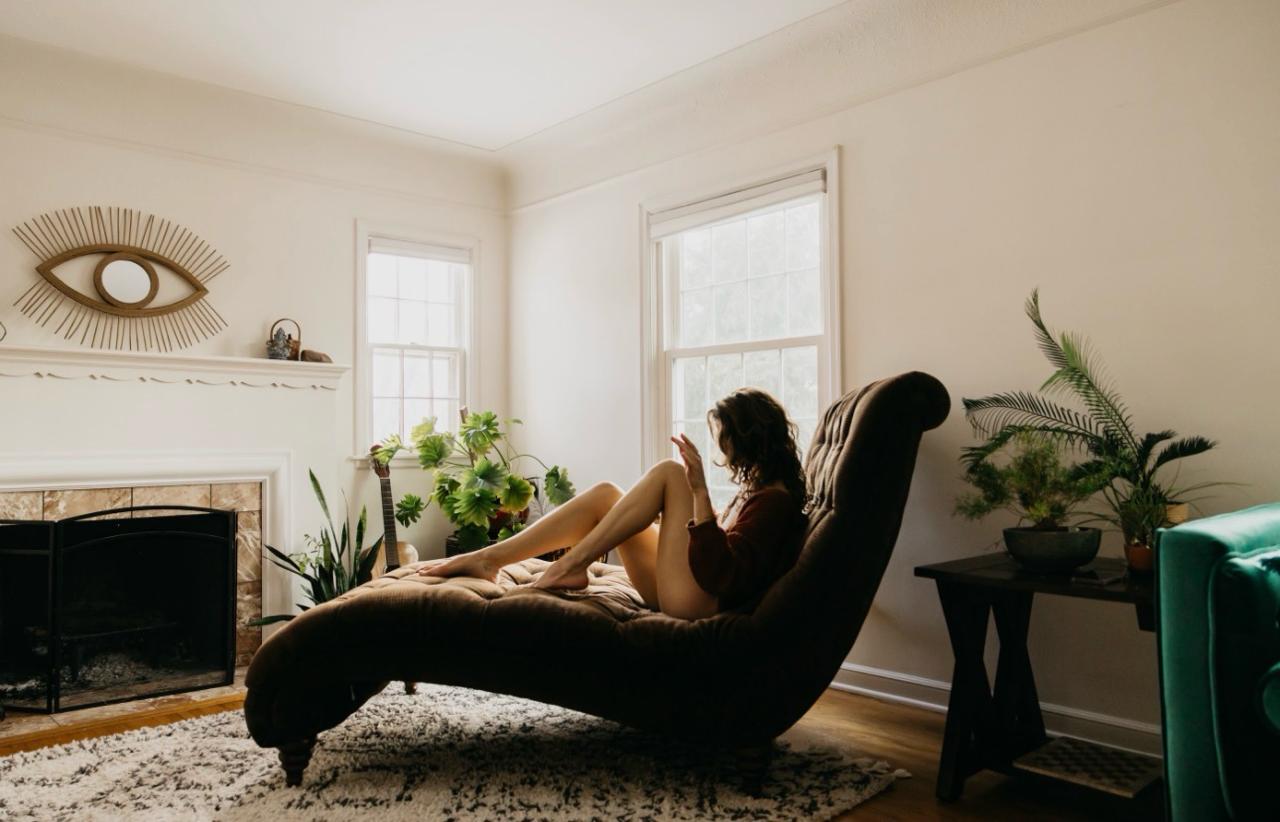 Interior of the tiny home with velvet chaise, plants, and warm window light